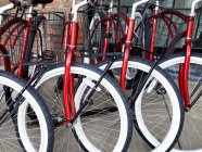 Identische rote Fahrräder, die auf der Straße von New York City, New York, Vereinigte Staaten geparkt sind — Stockfoto
