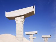 Soportes de paso elevado de carreteras enterrados en arena contra el cielo azul, McKinney, Texas, Estados Unidos - foto de stock