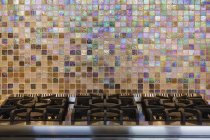 Cocina de gas y colorida pared de azulejos en el interior - foto de stock