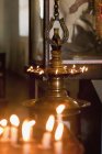 Metal ceremonial item with glowing lit candles indoors, Kerala, India — Stock Photo