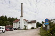 Parking lot of building with tall smokestack of Palmse Manor, Palmse, Estonia — Stock Photo