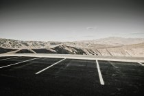 Desert parking spaces with hills and arid mountains in distance, Death Valley, California, United States — Stock Photo