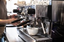Hände einer Barista, die mit kommerziellen Espressomaschinen Cappuccino zubereitet. — Stockfoto