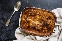 High angle view of freshly baked chicken pie and silver spoon. — Stock Photo