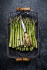 High angle view of freshly picked green asparagus in metal basket. — Stock Photo