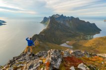 Mann genießt atemberaubende Aussicht von den Bergen auf den erhabenen Inseln, Norwegen, Europa. — Stockfoto
