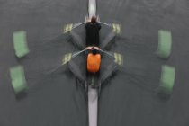 Blurred motion overhead view of double scull boat, two oarsmen in sculling boat on water. — Stock Photo