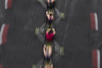 Blurred motion overhead view of rowing crew in sculling boat on water. — Stock Photo
