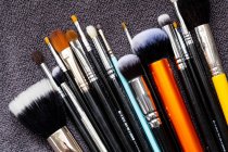 High angle close-up of selection of make-up brushes in various shapes and sizes. — Stock Photo