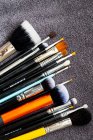 High angle close-up of selection of make-up brushes in various shapes and sizes. — Stock Photo