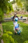Девочка-подросток и брат дерутся за воду в саду, опорожняют ведра с водой . — стоковое фото