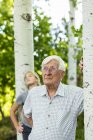 Senior grandfather with teen granddaughter in aspen forest — Stock Photo