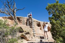 Family exploring Tsankawi Ruins in New Mexico and climbing up steps. — Stock Photo