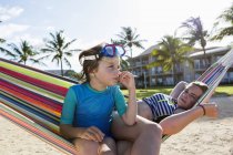 Elementary age boy in hammock with teen sister. — Stock Photo