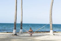 Женщина отдыхает в гамаке, вид сзади, остров Большой Кайман — стоковое фото