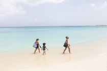 Madre con bambini che cammina sulla spiaggia in acqua, Grand Cayman Island — Foto stock