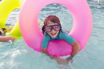 Ragazzo in età elementare che gioca in piscina con galleggiante colorato . — Foto stock