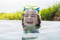 Lachendes Teenie-Mädchen ruht sich im Schwimmbad aus. — Stockfoto