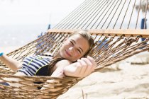 Блондинка-подросток отдыхает в гамаке на пляже . — стоковое фото