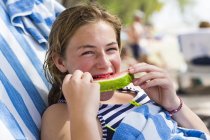Blondes Teenager-Mädchen isst Wassermelone am Strand. — Stockfoto
