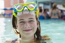 Blondes Teenager-Mädchen mit Brille schwimmt im Infinity-Pool. — Stockfoto