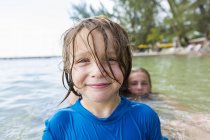 Улыбающийся дошкольник в мокрой рубашке в морской воде
. — стоковое фото