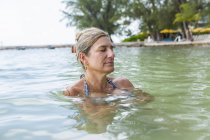 Mujer adulta relajándose en el agua del océano, Isla Gran Caimán - foto de stock