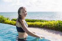 Ragazza bionda adolescente rilassante in piscina a sfioro . — Foto stock