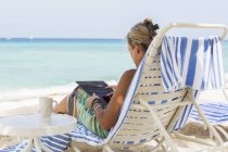 Femme cadre adulte utilisant un smartphone sur la plage, Grand Cayman Island — Photo de stock