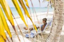 Взрослая женщина-руководитель с ноутбуком на пляже, остров Гранд Кайман — стоковое фото