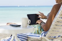 Esecutivo femminile adulto che utilizza laptop sulla spiaggia, Grand Cayman Island — Foto stock