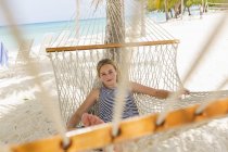 Chica adolescente relajándose en hamaca en la playa tropical . - foto de stock