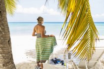 Donna adulta che avvolge in pareo colorato in spiaggia — Foto stock