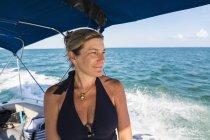 Sourire attrayant mature femme sur bateau dans l'eau de l'océan — Photo de stock