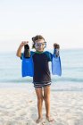 Little boy wearing snorkel mask and holding  blue flippers. — Stock Photo