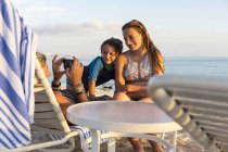 Mère prenant des photos d'enfants profitant de la plage au coucher du soleil, île Grand Cayman — Photo de stock