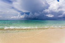 Strand auf tropischer Insel und Blick über das türkisfarbene Meer. — Stockfoto