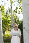 Blonde teen girl relaxing in aspen tree forest. — Stock Photo