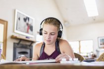Teenage girl at home wearing headphones as painting — Stock Photo