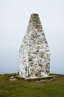 Cardigan Bay and stone cairn at entrance to Porthgain Harbour from Pembrokeshire Coast Trail, Pembrokeshire National Park, Wales, Uk. — стоковое фото