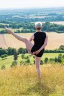 Задний вид женщины, практикующей йогу на открытом воздухе на склоне холма . — стоковое фото