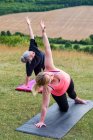 Deux femmes prenant part à un cours de yoga en plein air sur une colline . — Photo de stock
