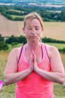 Reife Frau nimmt an Outdoor-Yoga-Kurs an einem Hang teil. — Stockfoto