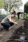 Two women working on freshly laid bed of soil in vegetable garden. — Stock Photo