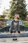 Portrait of elementary age boy posing in bed of old pick up truck — Stock Photo