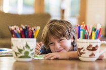 Малюнок хлопчика початкового віку з різними барвистими ручками — стокове фото