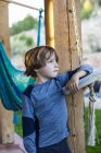 Portrait de pré-adolescent garçon appuyé sur balançoire dans le jardin — Photo de stock