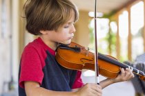 Menino pré-adolescente tocando violino fora no jardim — Fotografia de Stock