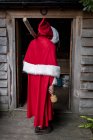 Vista posteriore dell'uomo che indossa il costume di Babbo Natale in piedi sulla porta dell'officina
. — Foto stock