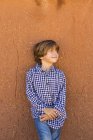 Portrait of pre-teen boy against adobe wall — Stock Photo